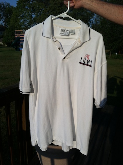 white golf shirt with UDM logo