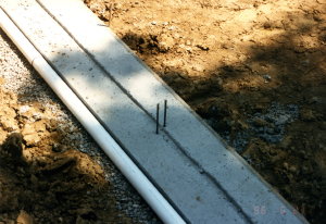 This is the drain tile at my own home. Note how the drain tile pipe is alongside the footer and the holes in the pipe are facing down. The pipe is also placed on a layer of clean gravel. PHOTO CREDIT: Tim Carter