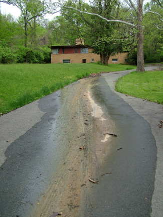 Look at the water from the active spring covering the driveway. It hasn't rained for nearly two days, yet water still is flowing out of the soil. The hill continues up behind the house for several hundred feet. Thousands of gallons of water are in the soil, working their way toward this spring. PHOTO CREDIT: Tim Carter