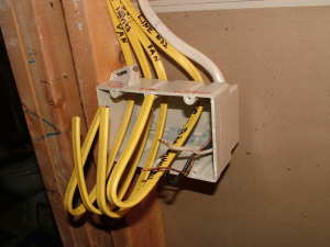 The different cables entering this electrical box can confuse a rookie electrician. There are strict guidelines that govern how electrical wiring must be installed. PHOTO CREDIT: Tim Carter