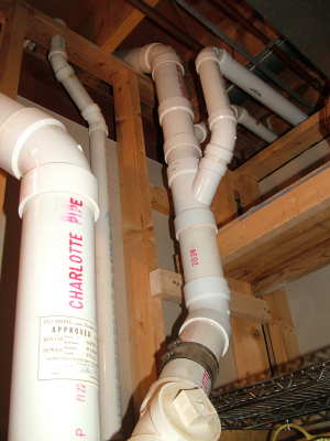 This convoluted assembly of pipes was installed by a licensed master plumber. You may be able to get professional results as a do-it-yourselfer, if you get help from a consulting plumber. PHOTO CREDIT: Tim Carter