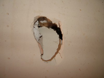 This nasty-looking hole in the drywall can be completely repaired in three hours or less with the right products.  PHOTO CREDIT: Tim Carter