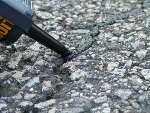 This blacktop crack can be repaired with a simple caulk gun and a tube of asphalt crack sealant. PHOTO CREDIT: Tim Carter
