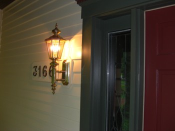 This outdoor sconce seems gigantic, but when viewed from a distance it's the perfect size for the door and porch. Note the custom mounting block behind the fixture. PHOTO CREDIT: Tim Carter