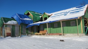 This house is being built in the middle of a harsh winter and they're making progress each day. The roof was covered with tarps so ice and snow will not cake on the sheathing. Photo Credit: Tim Carter